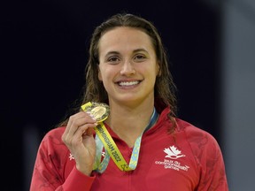 Kylie Masse of Canada poses after winning the gold medal in the Women's 50 meters backstroke final during the swimming competition of the Commonwealth Games, at the Sandwell Aquatics Centre in Birmingham, England, Wednesday, Aug. 3, 2022.
