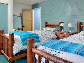 Türkisfarbene Seitenwände und klobige Blockmöbel von Pioneer Handcraft bezaubern in einem der Schlafzimmer.