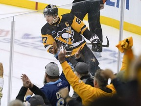 Fans cheer as Sidney Crosby celebrates his goal during the first period of the team's NHL hockey game against the Arizona Coyotes, in Pittsburgh, Thursday, Oct. 13, 2022. Crosby was named the first star as he led his Pittsburgh Penguins to two consecutive victories to open the season.