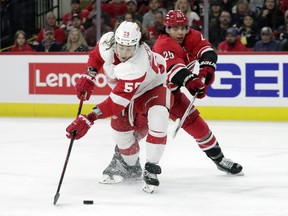 Detroit Red Wings left wing Tyler Bertuzzi (59) tries to evade Carolina Hurricanes defenseman Ethan Bear (25) as he handles the puck during the first period of an NHL hockey game Thursday, April 14, 2022, in Raleigh, N.C. The struggling Vancouver Canucks bolstered their lineup on Friday with the acquisition of defenceman Ethan Bear and forward Lane Pederson from the Carolina in exchange for a fifth-round draft pick.