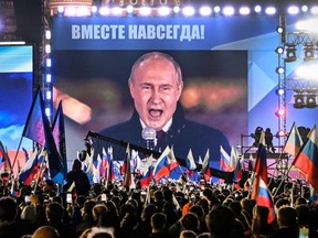 Russian President Vladimir Putin is seen on a screen at Red Square as he addresses a rally marking the annexation of four regions of Ukraine on Sept. 30, 2022.