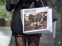 A woman holding an Aritzia shopping bag walking on Toronto’s Bloor Street West during the COVID-19 pandemic.