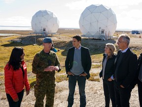 NATO Secretary General Jens Stoltenberg, right, speaks with Prime Minister Justin Trudeau, Defence Minister Anita Anand and Foreign Affairs Minister Mélanie Joly near radar domes during a visit to the Arctic community of Cambridge Bay, Nunavut, August 25, 2022.