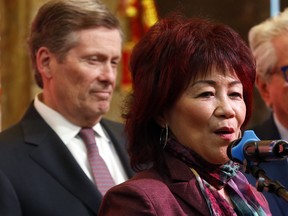 Toronto City Councillor Cynthia Lai speaks at an event while Mayor John Tory listens, in January 2020.