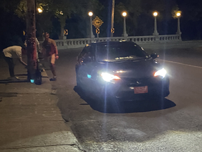 Civil servant Peter O’Neil sent this photo to Ottawa Police allegedly showing a group of Russian men jumping out of a car with diplomatic plates in order to vandalize some bikes owned by pro-Ukraine activists. For this, O’Neill got an “indefinite” ban from travel to the Russian Federation.