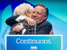 François Legault, leader of the Coalition Avenir Québec, hugs his wife, Isabelle Brais, as they celebrate his re-election as Quebec's premier on Oct. 3, 2022.