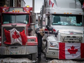 A woman greets a truck driver on Feb. 6, 2022, during the Freedom Convoy's protests in downtown Ottawa. An inquiry into the Liberal government's use of the Emergencies Act to end the protest began this week.