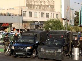 Riot police stand in a street in Tehran, on Oct. 3.