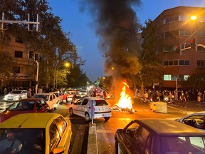 A police motorcycle burns during a protest over the death of Mahsa Amini, in Tehran, on Sept. 19.