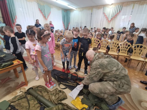 Russian kindergarteners learn about weapons from a army veteran.