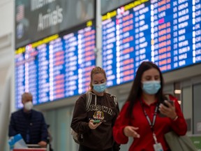 Travellers wear masks at Toronto International Pearson Airport on Sept. 26.