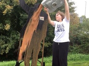 Climate protester Madeline “Maddie” Budd of the End UK Private Jets group pours a bucket of urine and feces over a memorial to the late Capt. Sir Tom Moore in a video posted on Twitter Sept. 30. Budd has been arrested.