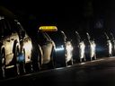 Taxis waits for customers on an unlit street in downtown Kyiv, on Oct. 20.