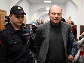 Russian opposition activist Vladimir Kara-Murza, right, is taken for a hearing in Moscow on October 10, 2022. Kara-Murza was jailed in April for denouncing the Kremlin's Ukraine offensive and has been charged with high treason, which could keep him behind bars for two decades.