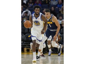 Golden State Warriors forward Andrew Wiggins (22) brings the ball up in front of Denver Nuggets forward Michael Porter Jr. during the second half of an NBA preseason basketball game in San Francisco, Friday, Oct. 14, 2022.