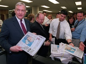 'More myth than mortal': Conrad Black hands out copies of the first issue of the National Post to the Post staff in the Toronto newsroom, October 27, 1998.