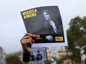 FILE - A protester shows a portrait of Mahsa Amini during a demonstration to support Iranian protesters standing up to their leadership over the death of a young woman in police custody, Sunday, Oct. 2, 2022 in Paris. Anti-government demonstrations erupted Saturday, Oct. 8, in several locations across Iran as the most sustained protests in years against a deeply entrenched theocracy entered their fourth week. The protests erupted Sept. 17, after the burial of 22-year-old Amini, a Kurdish woman who had died in the custody of Iran's feared morality police.