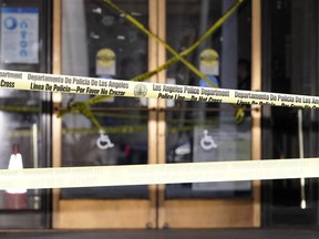 Police tape put up by protesters blocks the entrance of Los Angeles City Hall, Wednesday, Oct. 19, 2022, in Los Angeles. The demonstrators demanded the city council stop its virtual meeting Tuesday until two of its members resign over racist remarks.