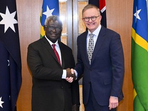 Australian Prime Minister Anthony Albanese, right, and Solomon Islands Prime Minister Manasseh Sogavare shake hands ahead of a bilateral meeting at Parliament House in Canberra, Australia, Thursday, Oct. 6, 2022.