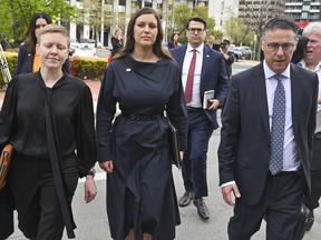 Former Liberal staffer Brittany Higgins, center, arrives at the Australian Capital Territory Supreme Court in Canberra, Australia, Tuesday, Oct. 4, 2022. A judge reminded potential jurors in a high-profile Australian rape trial on Tuesday of the importance of impartiality. Former government staffer Bruce Lehrmann is charged with raping fellow staffer Brittany Higgins in the then-Defense Industry Minister Linda Reynolds' office in Parliament House in March 2019.