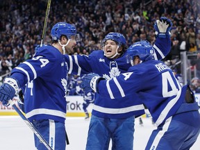 Toronto Maple Leafs left wing Nicholas Robertson (89), centre Auston Matthews (34) and defenceman Morgan Rielly (44) celebrate Robertson's overtime goal during NHL hockey action against the Dallas Stars in Toronto on Thursday, October 20, 2022.