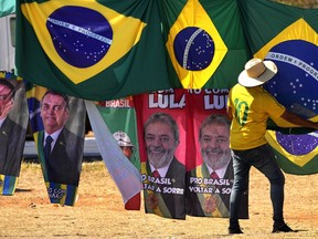 FILE - Presidential election campaign flags hang for sale, featuring the faces of both current President Jair Bolsonaro, left, and former President Luiz Inacio Lula da Silva, outside the Supreme Electoral Court in Brasilia, Brazil, Sept. 5, 2022. Bolsonaro will face da Silva in the Oct. 30 runoff for president.