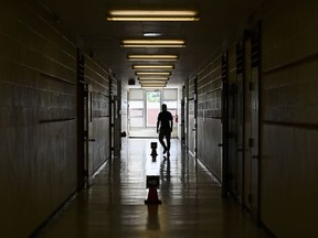 A person walks in the hall at a school in Scarborough, Ont., on Monday, September 14, 2020.&ampnbsp;The union representing about 55,000 Ontario education workers has given five days' notice of a potential provincewide strike.