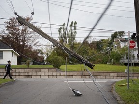 A snapped power pole hangs over a street in New Glasgow, N.S. on Wednesday, September 28, 2022 following significant damage brought by post tropical storm Fiona.