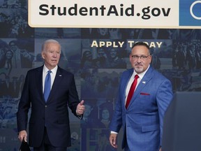 President Joe Biden answers questions with Education Secretary Miguel Cardona as they leave an event about the student debt relief portal beta test in the South Court Auditorium on the White House complex in Washington, Monday, Oct. 17, 2022.
