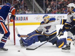 St. Louis Blues goalie Jordan Binnington (50) makes a save as Edmonton Oilers' Leon Draisaitl (29) and Justin Faulk (72) look for the rebound during second period NHL action in Edmonton on Saturday, October 22, 2022.THE CANADIAN PRESS/Jason Franson