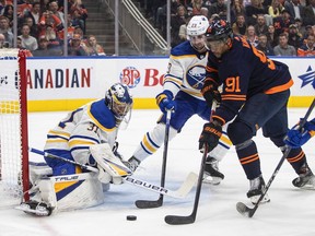 Buffalo Sabres goalie Eric Comrie (31) makes the save on Edmonton Oilers' Evander Kane (91) as Mattias Samuelsson (23) defends during second period NHL action in Edmonton on Tuesday, October 18, 2022.THE CANADIAN PRESS/Jason Franson