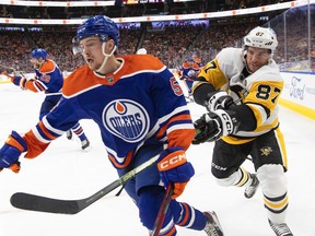 Pittsburgh Penguins' Sidney Crosby (87) hooks Edmonton Oilers' Kailer Yamamoto (56) during second period NHL action in Edmonton on Monday, October 24, 2022.THE CANADIAN PRESS/Jason Franson