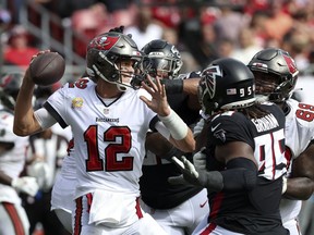Tampa Bay Buccaneers quarterback Tom Brady (12) throws under pressure from Atlanta Falcons defensive tackle Ta'Quon Graham (95) during the second half of an NFL football game Sunday, Oct. 9, 2022, in Tampa, Fla.