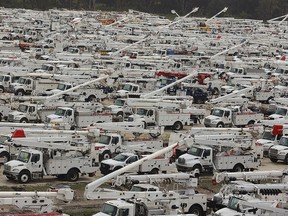 Utility trucks are staged in a rural lot in The Villages of Sumter County, Fla., Wednesday, Sept. 28, 2022. Hurricane Ian rapidly intensified as it neared landfall along Florida's southwest coast Wednesday morning, gaining top winds of 155 mph (250 kph), just shy of the most dangerous Category 5 status.