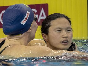 Margaret Mac Neil, right, of Canada is congratulated after winning the women's 100m butterfly at the FINA Swimming World Cup meet in Toronto, Sunday, Oct. 30, 2022.