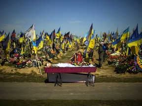 The body of recently killed Ukrainian serviceman Vadim Bereghnuy, 22, rests in a coffin during his funeral in a cemetery in Kharkiv, Ukraine, Monday, Oct. 17, 2022.