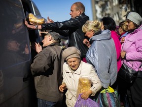 Locals receive food and everyday necessities given by Ukrainian volunteers in Izium, Ukraine, Wednesday, Oct. 12, 2022. Residents in Izium have been living with no gas, electricity or running water supply since the beginning of September.