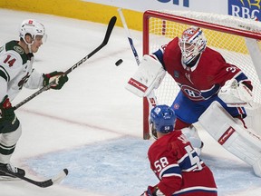 Minnesota Wild's Joel Eriksson Ek (14) moves in on Montreal Canadiens goaltender Jake Allen during first period NHL hockey action in Montreal, Tuesday, October 25, 2022.