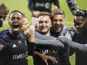 CF Montreal's Djordje Mihailovic, centre, celebrates with teammates after scoring from the penalty spot against Orlando City SC during second half MLS playoff soccer action in Montreal, Sunday, Oct. 16, 2022.