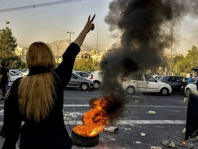 FILE - In this photo taken by an individual not employed by the Associated Press and obtained by the AP outside Iran, Iranians protests the death of 22-year-old Mahsa Amini after she was detained by the morality police, in Tehran, Oct. 1, 2022. As protests rage at home, Iran's theocratic government is increasingly flexing its military muscle abroad. That includes supplying drones to Russia that now kill Ukrainian civilians, running drills in a border region with Azerbaijan and bombing Kurdish positions in Iraq.