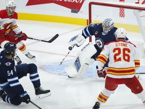 Winnipeg Jets goaltender David Rittich (33) saves the shot from Calgary Flames' Michael Stone (26) during first period NHL pre-season game action in Winnipeg on Wednesday, October 5, 2022.
