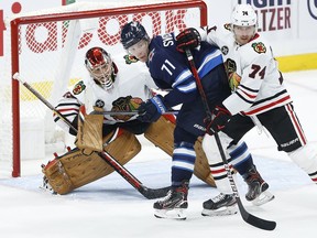 Chicago Blackhawks' defenceman Nicolas Beaudin (74) works to clear Winnipeg Jets' Evgeny Svechnikov (71) from in front of goaltender Marc-Andre Fleury (29) during third period NHL action in Winnipeg on Friday, November 5, 2021.The Montreal Canadiens acquired Beaudin from the Chicago Blackhawks in a trade for centre Cam Hillis on Wednesday.THE CANADIAN PRESS/John Woods