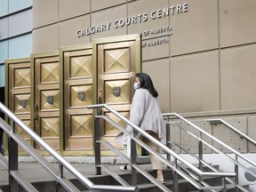 A woman wears a mask as she enters the Calgary Courts Centre during COVID-19 restrictions in Calgary, Monday, May 17, 2021. Alberta's provincial court will be renamed the Alberta Court of Justice.