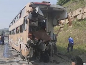 This image from video shows the mangled remains of a bus that collided with a truck on a highway in Rewa district of Madhya Pradesh state, India, Saturday, Oct.22, 2022. More than a dozen people were killed and dozens were injured in the accident. (K K Productions via AP)
