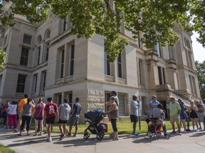 FILE - A long line of voters wraps around the Sedgwick County Historic Courthouse in Wichita, Kan., on the last day of early voting on Aug. 1, 2022. Kansas' top elections official warned voters Monday, Oct. 31, 2022, that text messages they were receiving could give them incorrect information about where to vote, but two national groups involved in the texting said they were not trying to confuse or mislead people.