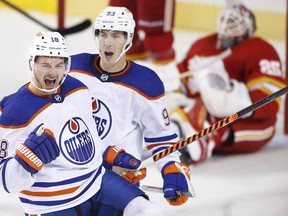 Edmonton Oilers' Zach Hyman, left, celebrates his goal against the Calgary Flames with Ryan Nugent-Hopkins, during third period NHL hockey action in Calgary, Saturday, Oct. 29, 2022.