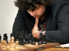 FILE - Chess Grandmaster Hans Niemann, 19, studies the board during a match against Grandmaster Christopher Yoo, 15, at the U.S. Chess Championship in St. Louis on Wednesday, Oct. 5, 2022. The U.S. Chess Championships opened play at the St. Louis Chess Club this week. Players, including 19-year-old Niemann, were greeted by a bevy of beefed-up security measures. They were scanned by security wands designed to detect not just metal but silicon, commonly used in electronics.