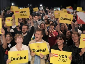 Supporters of Austrian President Alexander Van der Bellen react after hearing first results of the Austrian Presidential election in Vienna, Austria, Sunday, Oct. 9, 2022. Signs read "thank you".