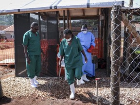 A medical attendant disinfects the rubber boots of a medical officer before leaving the Ebola isolation section of Mubende Regional Referral Hospital, in Mubende, Uganda Thursday, Sept. 29, 2022. In this remote Ugandan community facing its first Ebola outbreak, testing trouble has added to the challenges with symptoms of the Sudan strain of Ebola now circulating being similar to malaria, underscoring the pitfalls health workers face in their response.