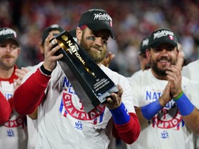 Philadelphia Phillies designated hitter Bryce Harper celebrates with the trophy after winning the baseball NL Championship Series in Game 5 against the San Diego Padres on Sunday, Oct. 23, 2022, in Philadelphia.